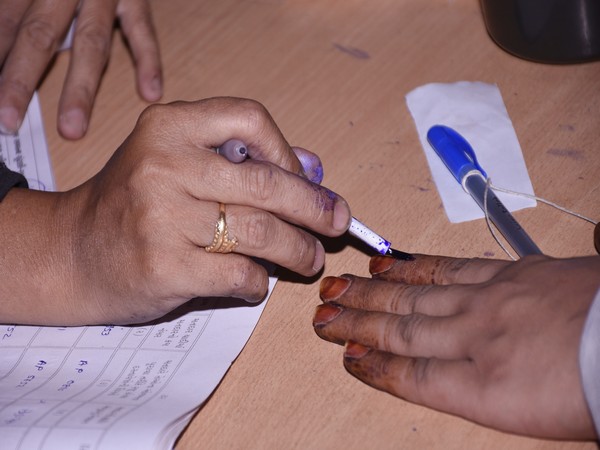 Surat, Dec 01 (ANI): A polling official applies inedible ink on a voter's finger after casting vote for the first phase of the Gujarat Assembly elections, at a school, in Surat on Thursday. (ANI Photo)